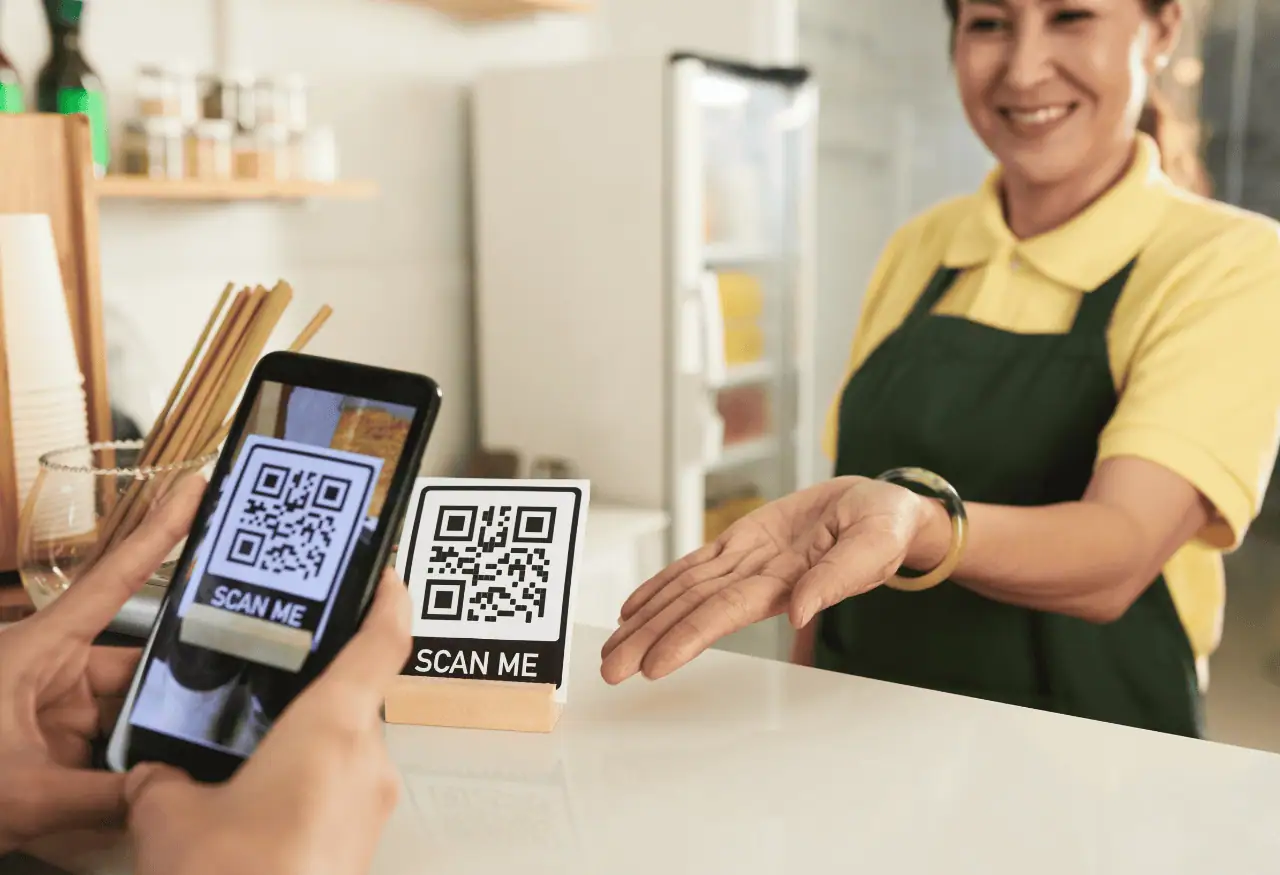 Customer scanning a QR code at checkout with a simple “scan me” prompt and no sales message