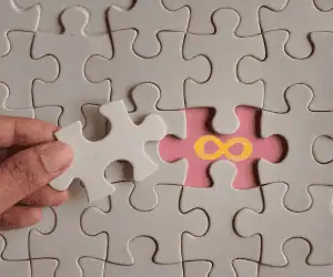 A conceptual image of a hand completing a puzzle with an infinity symbol, representing the persistent branded presence provided by an enterprise wallet pass platform. This visual illustrates how a native mobile wallet pass completes a brand’s loyalty marketing ecosystem by providing a permanent, high-utility home for a digital loyalty card that ensures long-term customer retention and engagement.