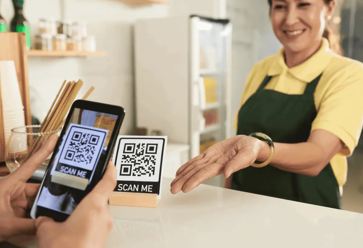 Customer scanning a QR code on a coffee shop counter to join a cafe loyalty program with one tap