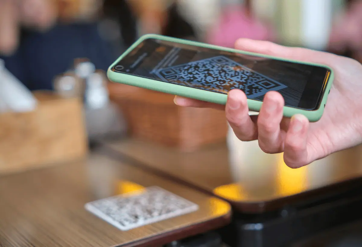Shopper scanning a QR code with their phone to join a boutique loyalty program