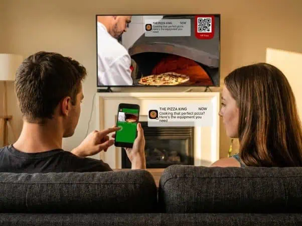 QR code advertising showing a wallet pass being added to a phone from a QR code displayed during a connected TV ad